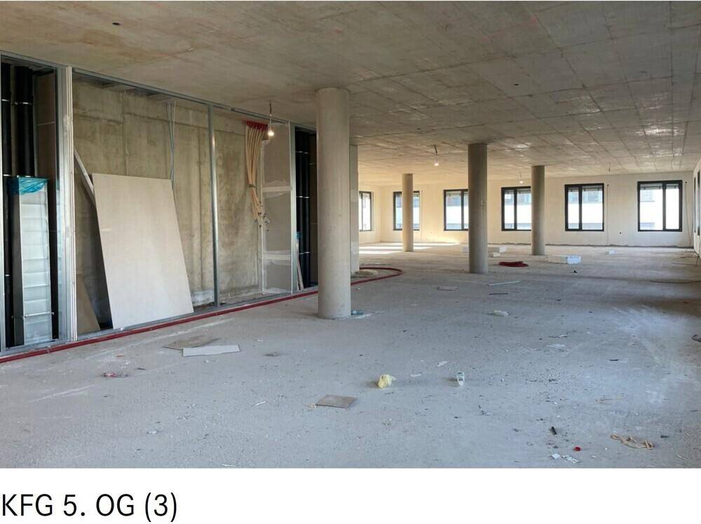 Großer Büroraum im Rohbau mit Betonsäulen und vorbereiteten Wänden für den weiteren Ausbau.