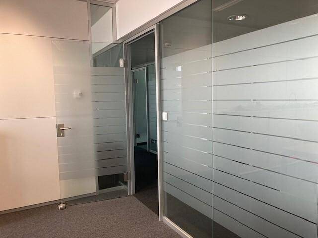 Moderne Bürotüren aus satiniertem Glas mit horizontalen Streifen für Privatsphäre.