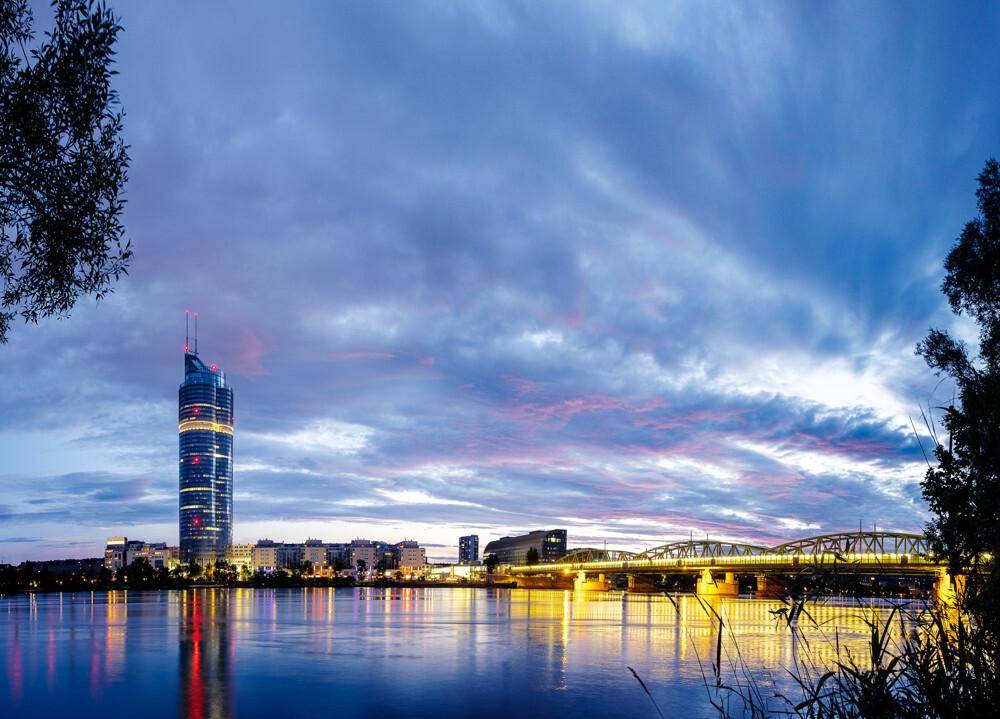 Beeindruckender Abendblick auf den Millennium Tower und die Donau bei Sonnenuntergang.