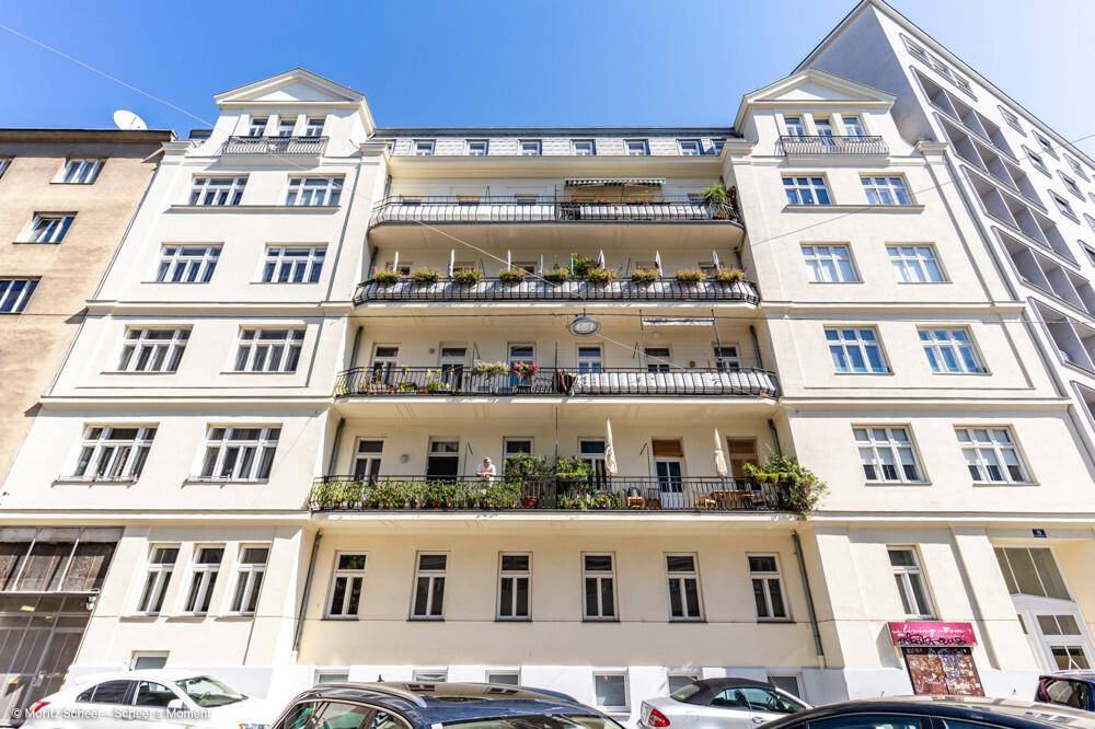 Klassische Altbaufassade mit mehreren Balkonen und schmiedeeisernen Geländern, die das Stadtbild prägt.