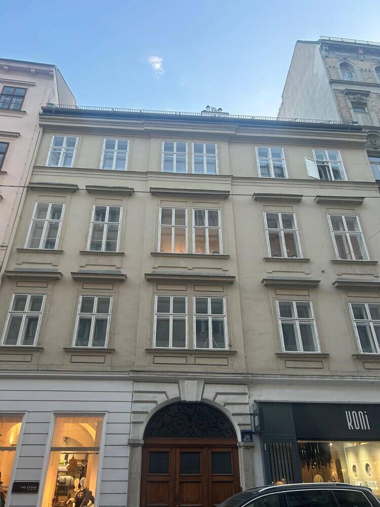 Historische Fassade eines Mehrfamilienhauses mit vielen Fenstern und klassischer Architektur in der Stadt.