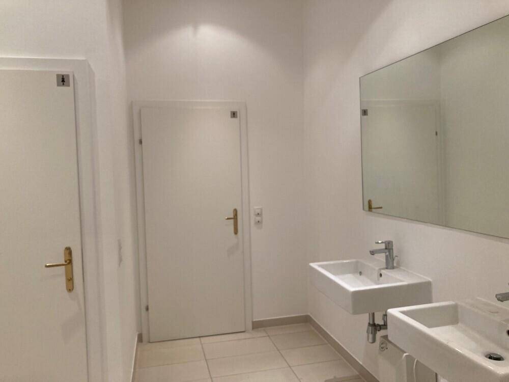 Modernes Badezimmer mit zwei Waschbecken, großem Spiegel und hellen Fliesen, sehr gepflegt.