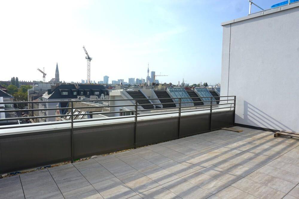 Dachterrasse mit weitem Blick über die Stadt, inklusive Kränen und der urbanen Skyline im Hintergrund.