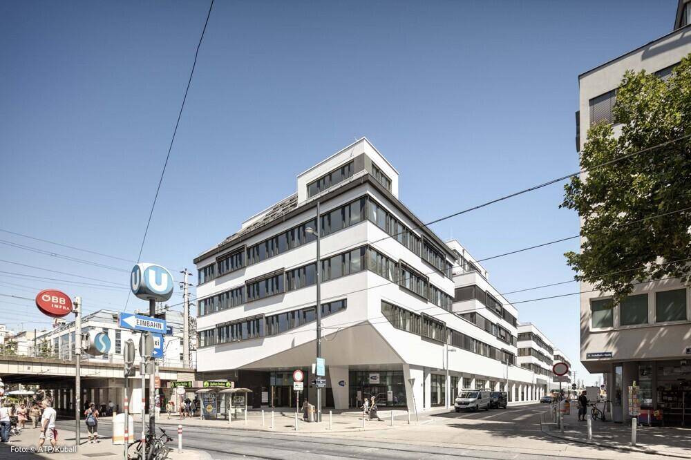 Zeitgenössisches Geschäftsgebäude mit markanter Architektur und großen Fensterfronten in urbaner Umgebung.