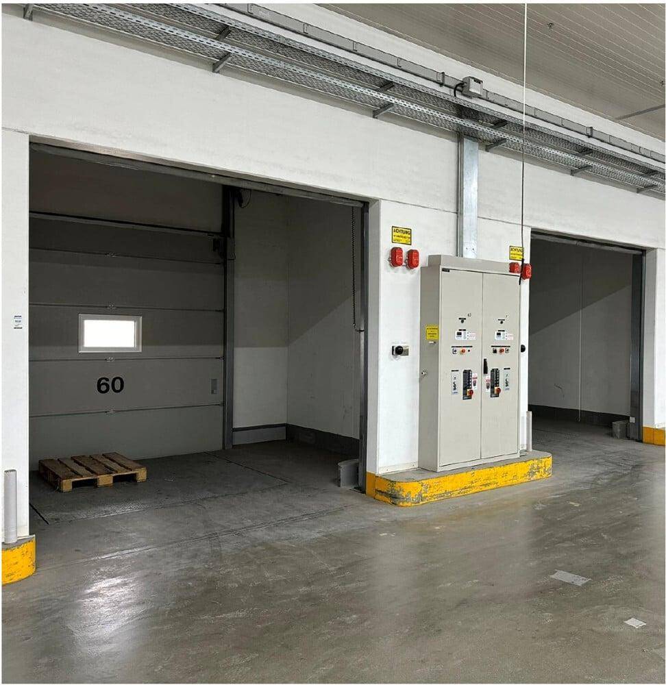 Nahaufnahme eines Laderampentors und eines elektrischen Schaltschranks im Innenbereich des Logistikzentrums.
