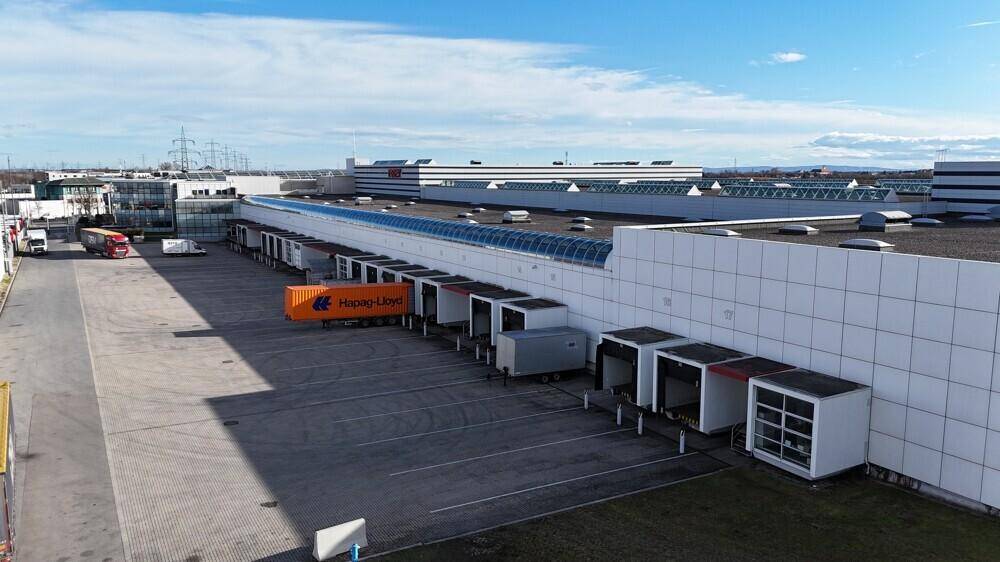 Laderampen eines Logistikzentrums mit mehreren Andockstationen und einem Container auf dem Vorplatz.