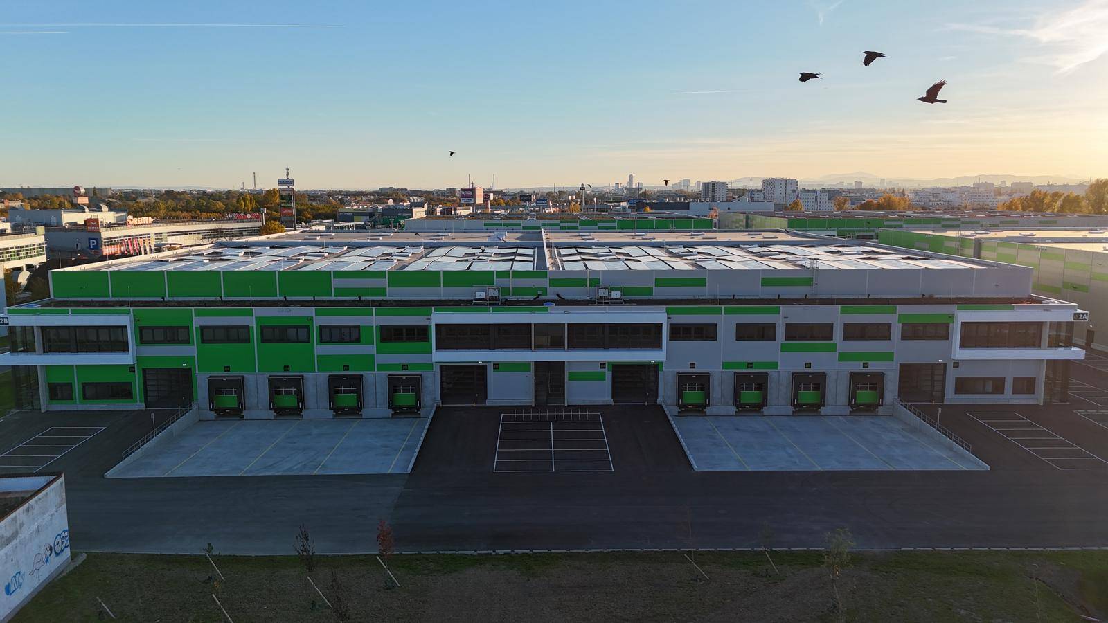 Luftaufnahme einer großen Gewerbeanlage mit zahlreichen Laderampen und einer modernen, funktionalen Architektur.