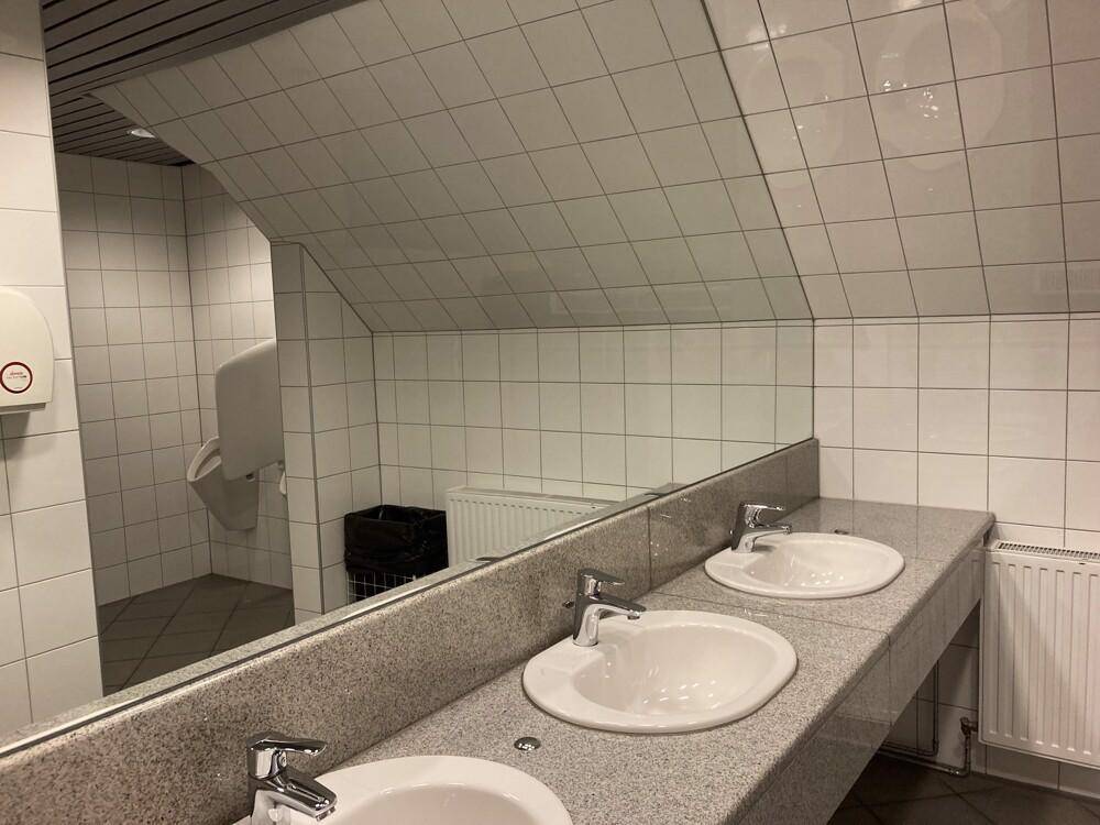 Modernes Badezimmer mit zwei Waschbecken, großem Spiegel und gefliesten Wänden.