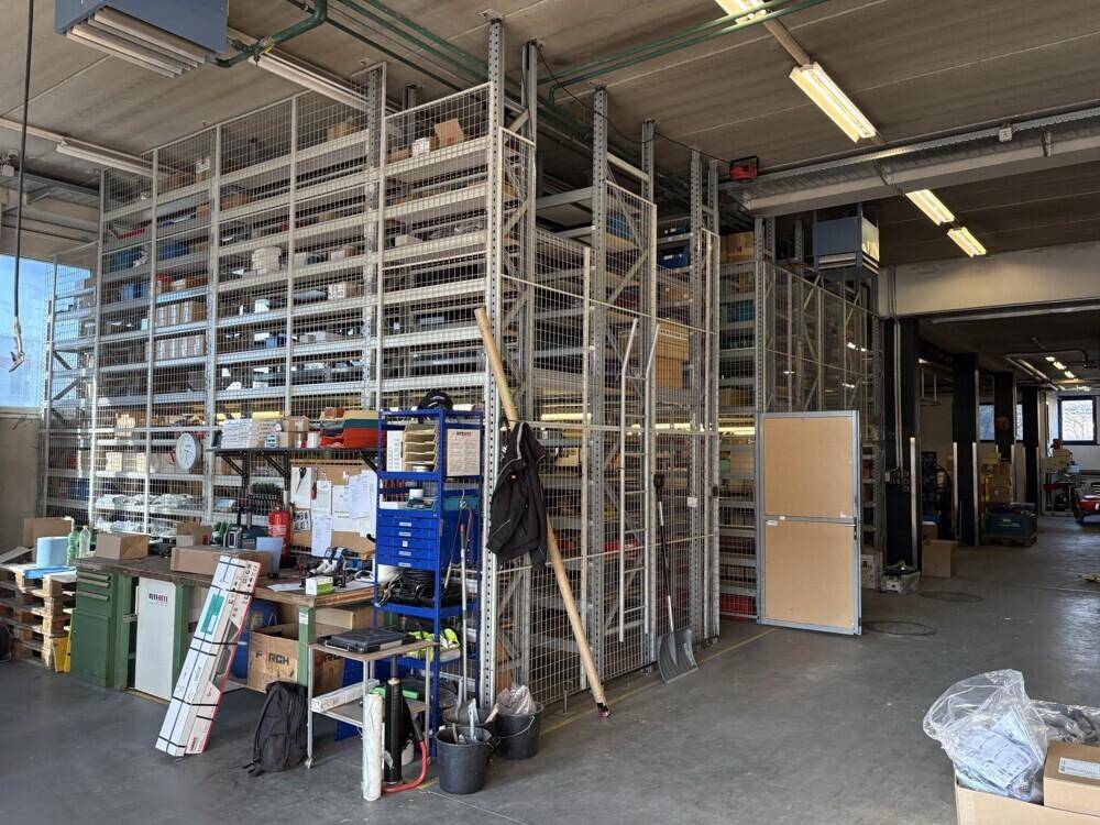 Voll ausgestatteter Lagerraum mit hohen Regalen, gefüllt mit verschiedenen Materialien und Werkzeugen.