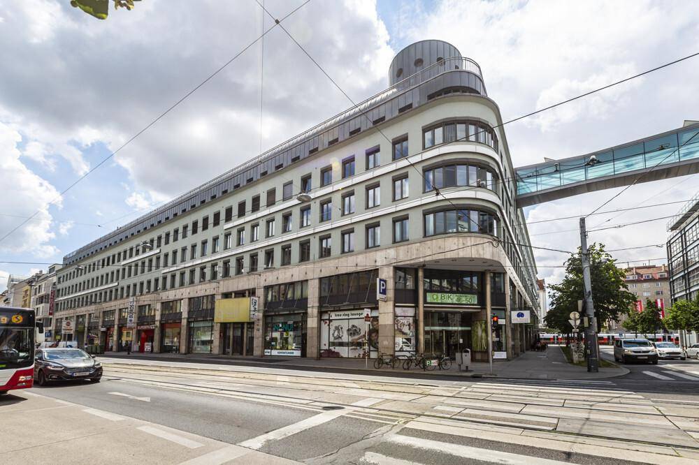 Weitläufige Ansicht des modernen Gebäudes mit seiner charakteristischen Architektur und dem belebten Stadtbild.