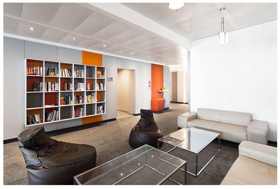 Gemütlicher Loungebereich im Büro mit Sofas, Sitzsäcken und Bücherregal.