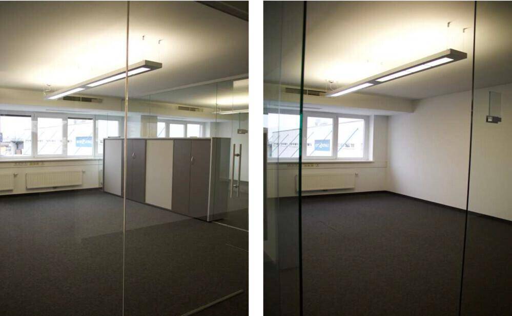 Heller Büroraum mit Teppichboden, Glaswänden und Blick nach draußen.