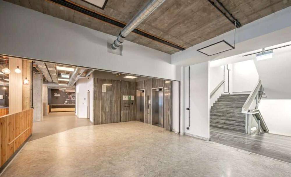 Eingangsbereich mit Treppenhaus, Aufzügen und offenem Blick in den Bürobereich.
