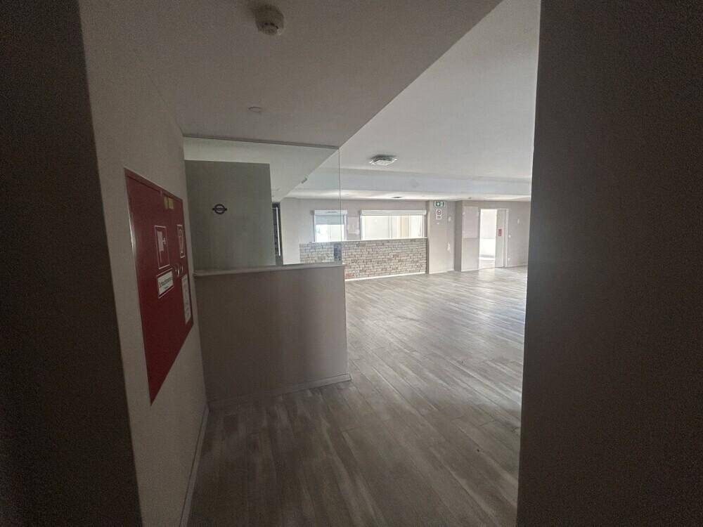 Blick durch einen Türrahmen in einen großen, offenen Bürobereich mit Steinwandakzent.