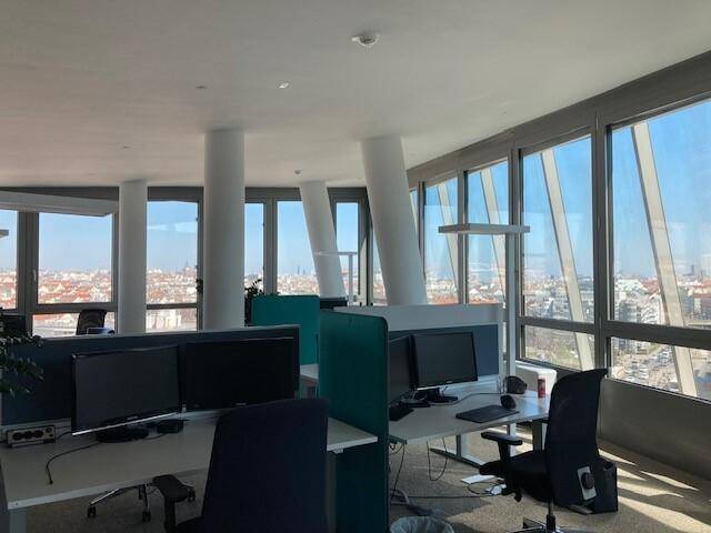 Großraumbüro mit Panoramablick über die Stadt, modernen Arbeitsplätzen und viel natürlichem Licht.
