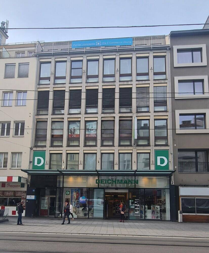 Fassade eines Geschäftsgebäudes mit Einzelhandelsfläche im Erdgeschoss und Büros darüber, mit Mietanzeige.