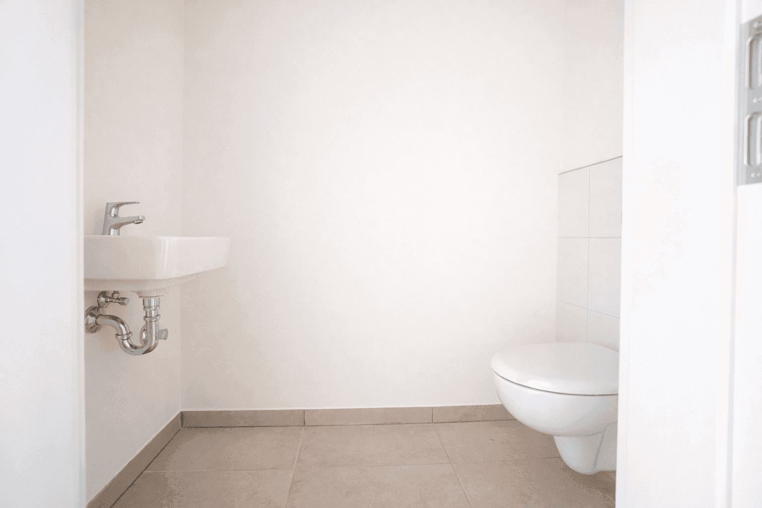 Helles Gäste-WC mit wandhängender Toilette und kleinem Waschbecken.