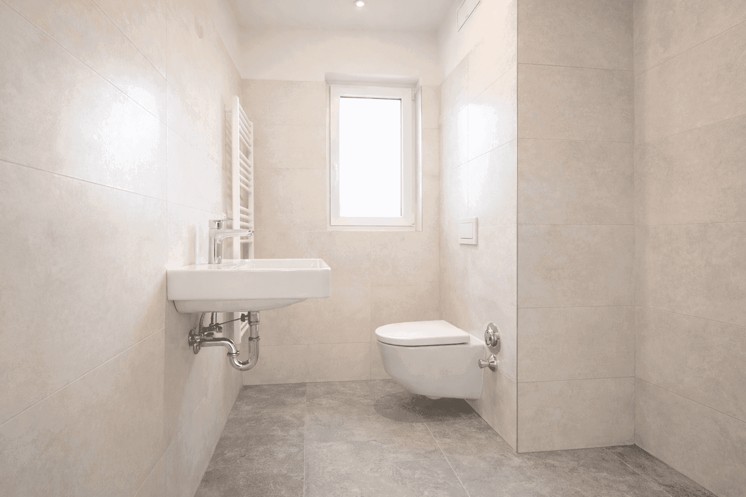 Helles Badezimmer mit Einzelwaschbecken, wandhängendem WC und Fenster.