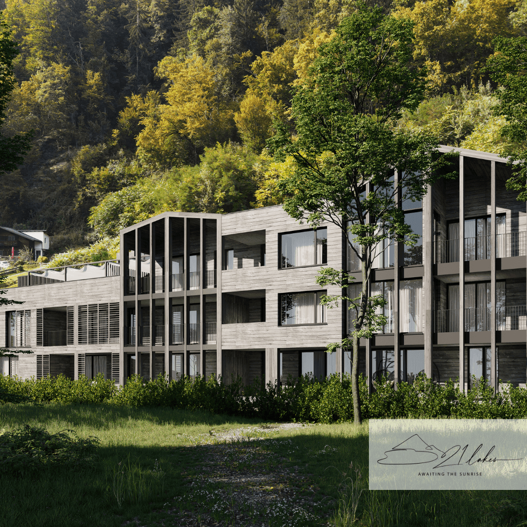 Zeitgenössisches Gebäude mit Holzverkleidung und großen Glasflächen, eingebettet in eine bewaldete Landschaft.
