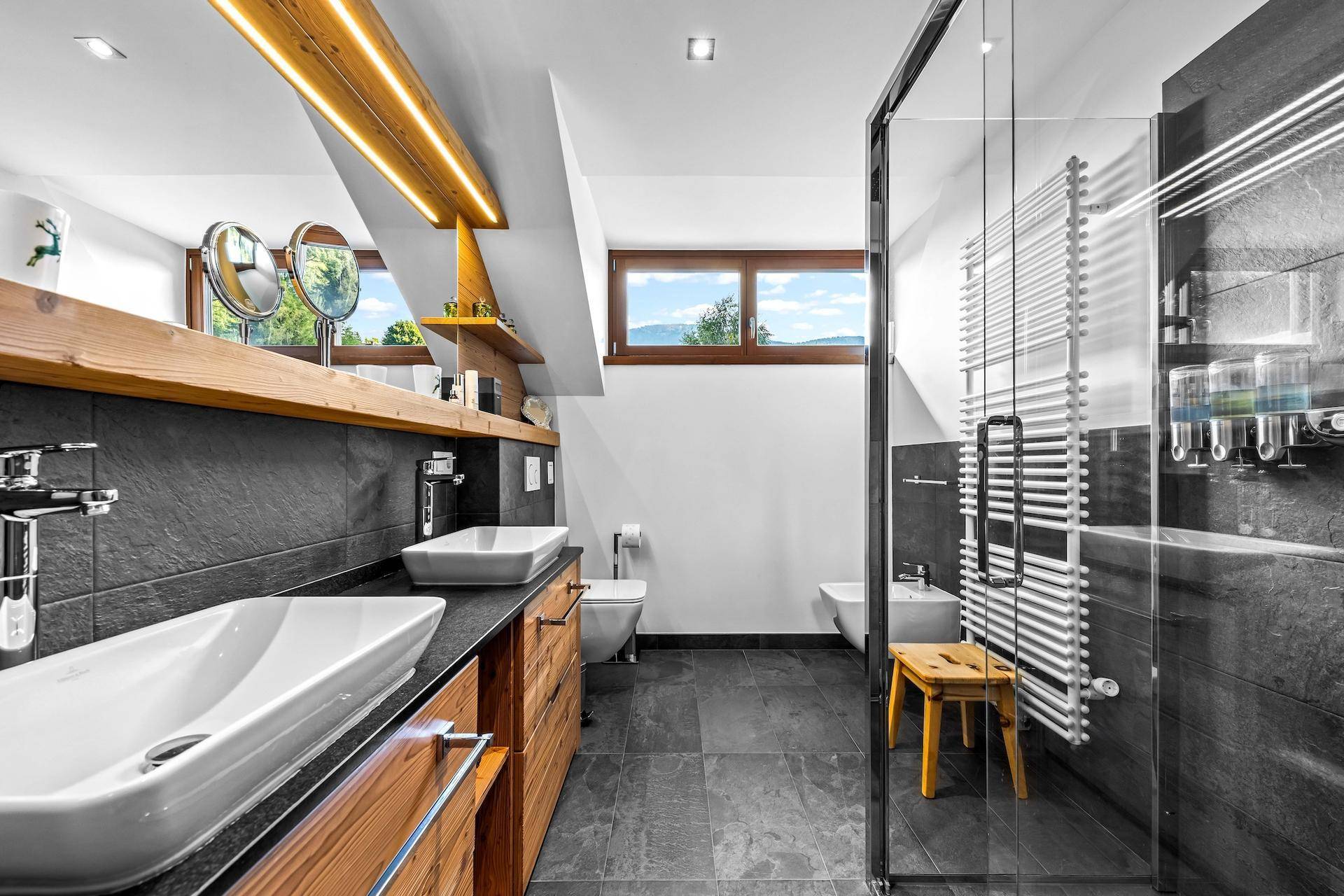 Modernes Badezimmer mit Doppelwaschbecken, begehbarer Dusche und Bergblick.