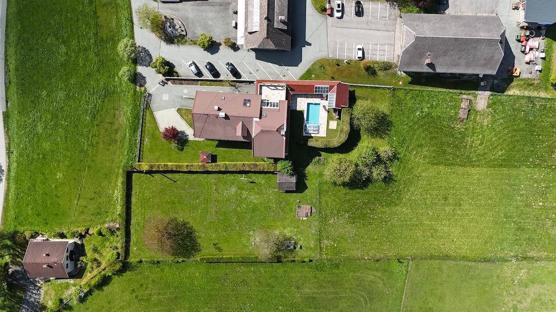 Detaillierte Luftaufnahme eines Anwesens mit Swimmingpool und weitläufiger Rasenfläche.