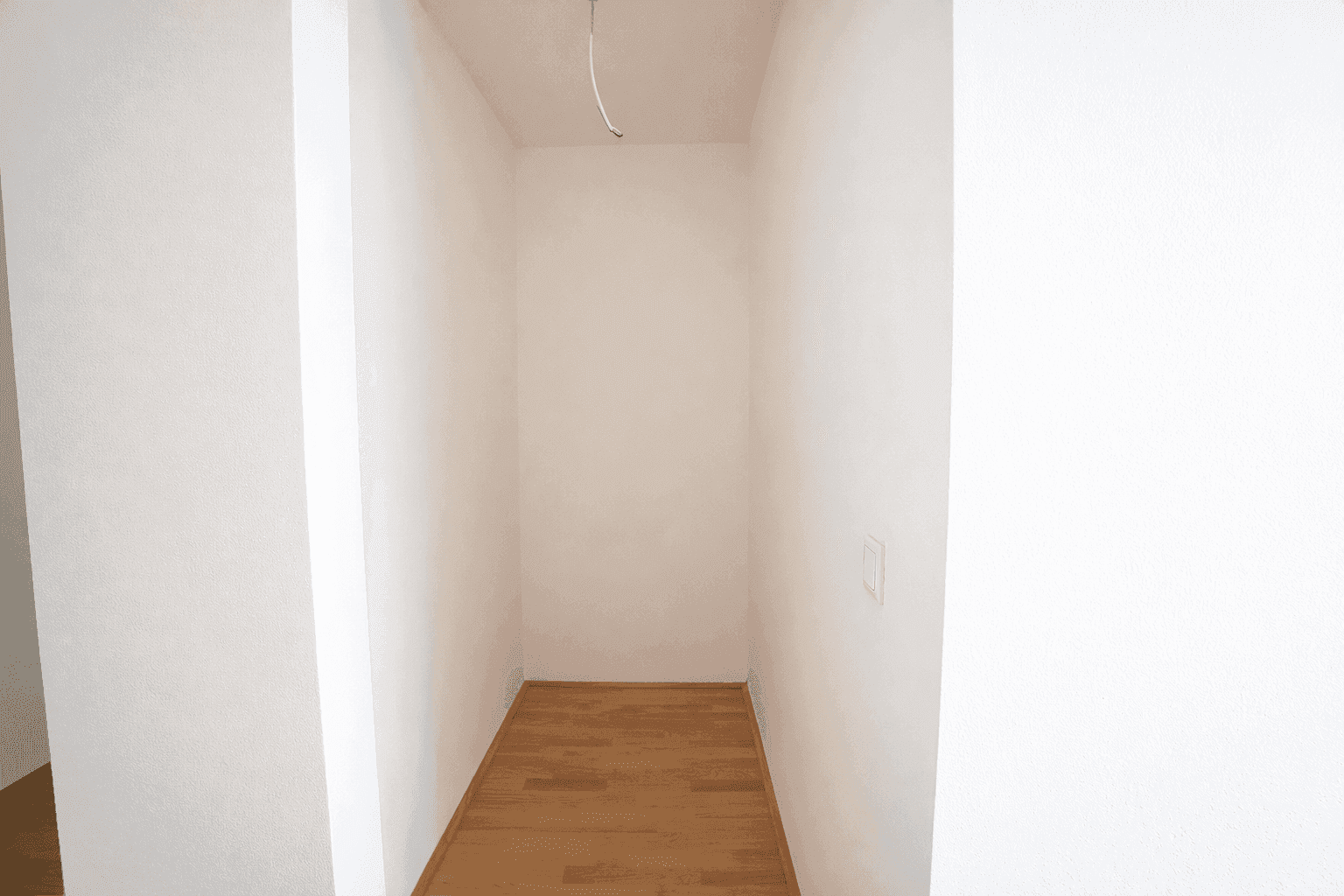 Leerer Abstellraum mit hellem Parkettboden, ideal für zusätzlichen Stauraum.