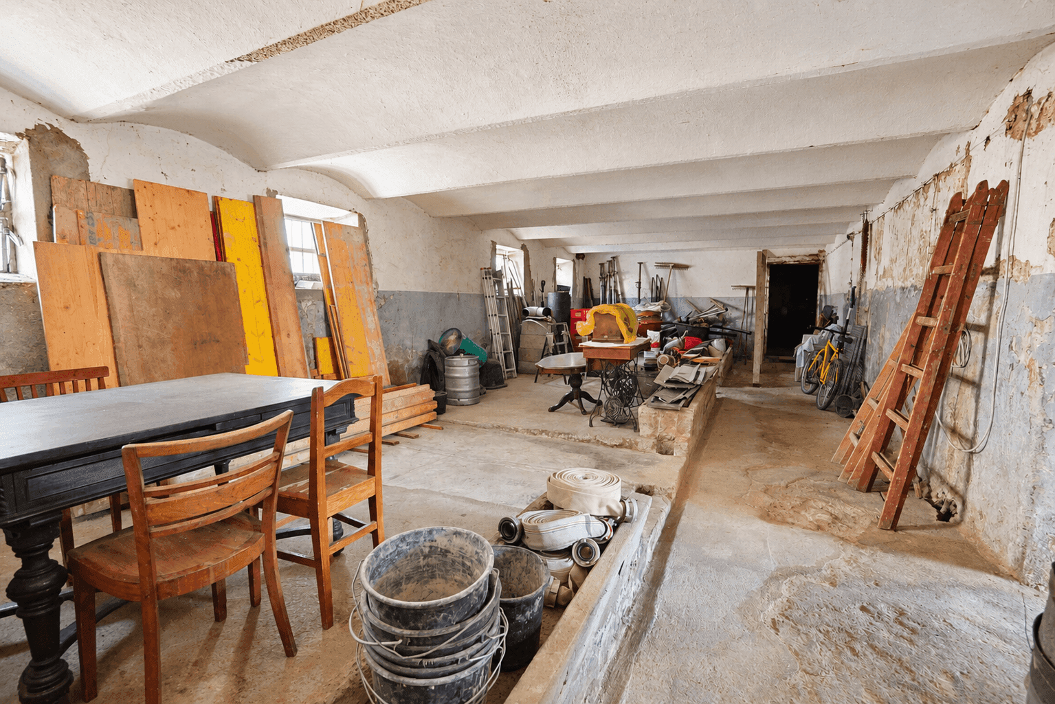 Großer Kellerraum mit Betonboden und verschiedenen Gegenständen, ideal als Lagerfläche.