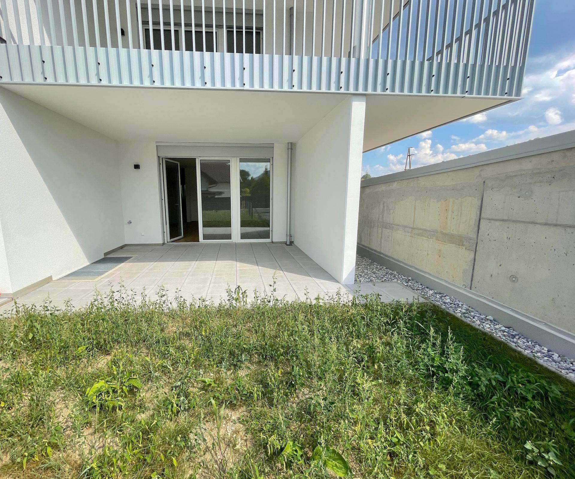 Große, geflieste Terrasse mit Zugang zum Gartenbereich und Blick auf die Umgebung.