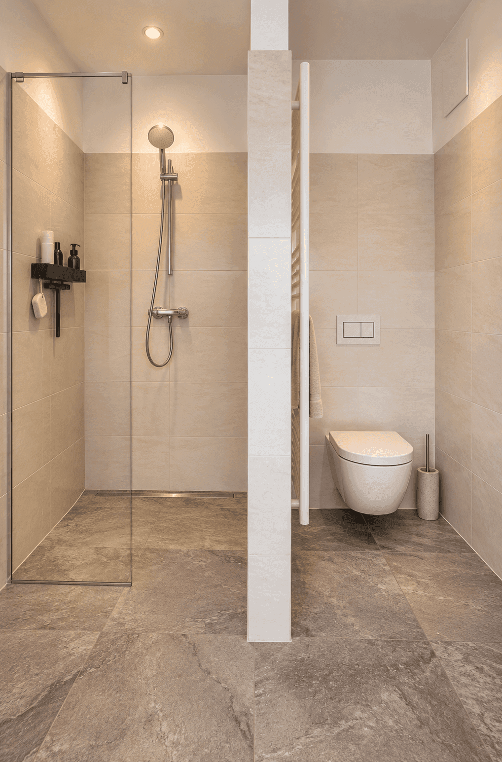 Modernes Badezimmer mit ebenerdiger Dusche und wandhängendem WC, in hellen Fliesen gehalten.