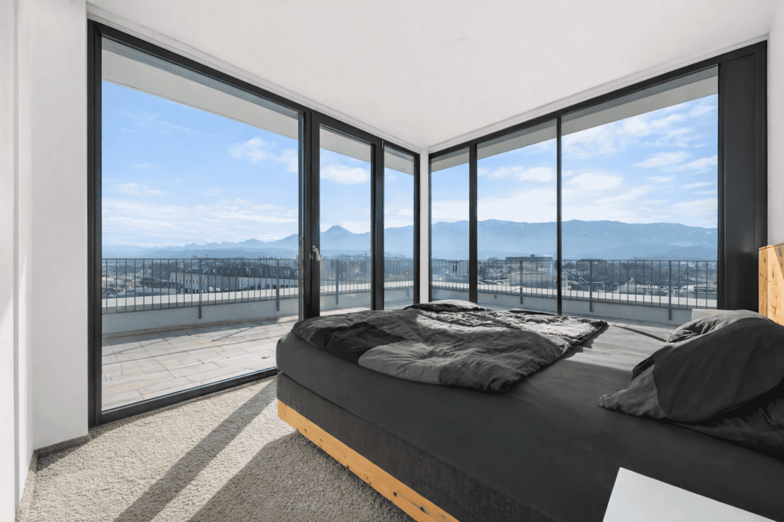 Schlafzimmer mit Teppichboden und raumhohen Fenstern, die Zugang zur Terrasse und Bergblick bieten.