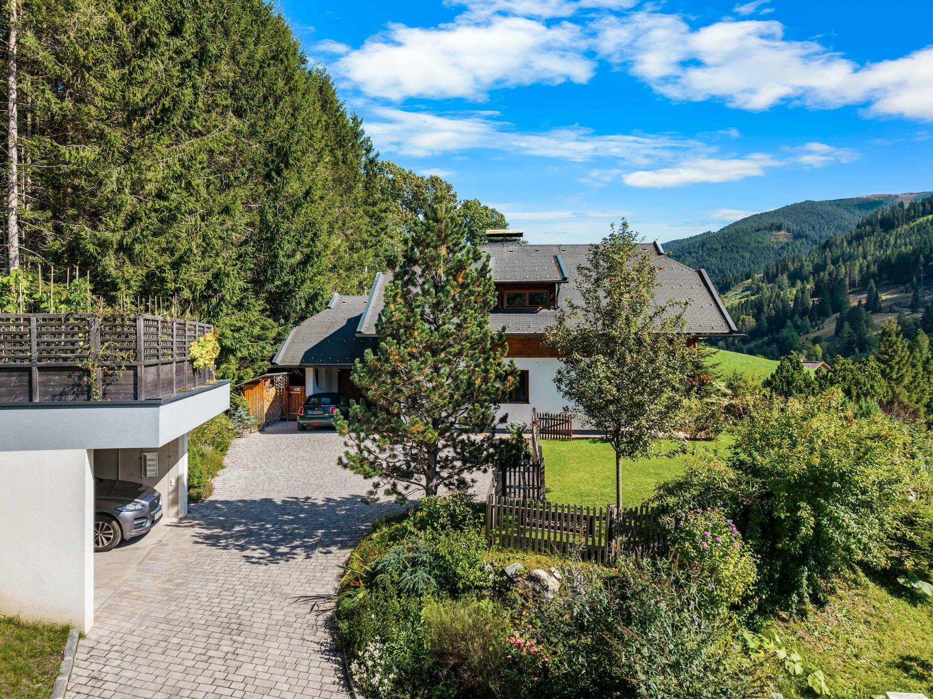 Charmantes Chalet mit gepflegtem Garten, Auffahrt und Carport in grüner Umgebung.
