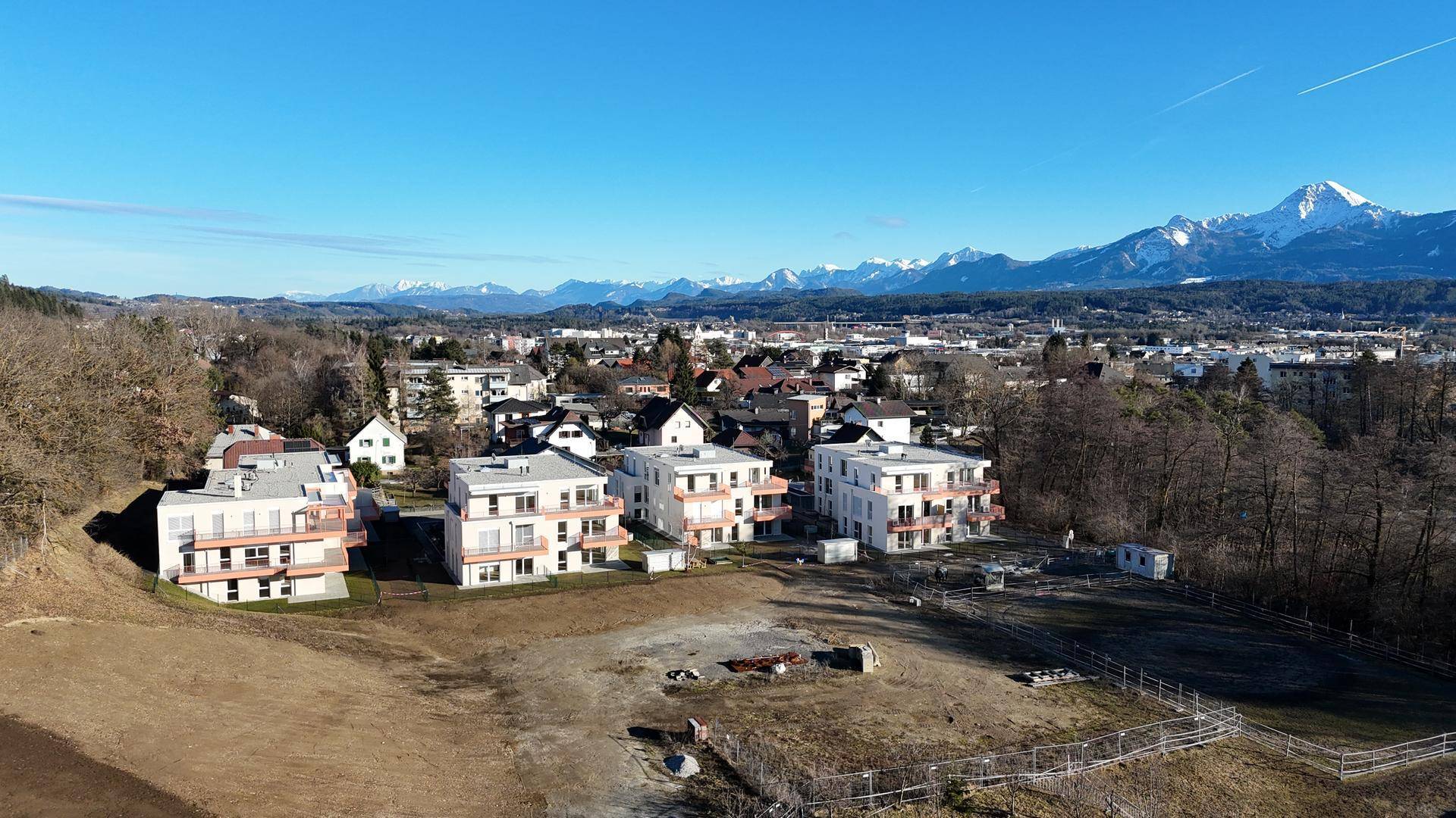 Luftaufnahme der Neubauwohnungen in einer ländlichen Umgebung mit Bergblick und viel Grün.