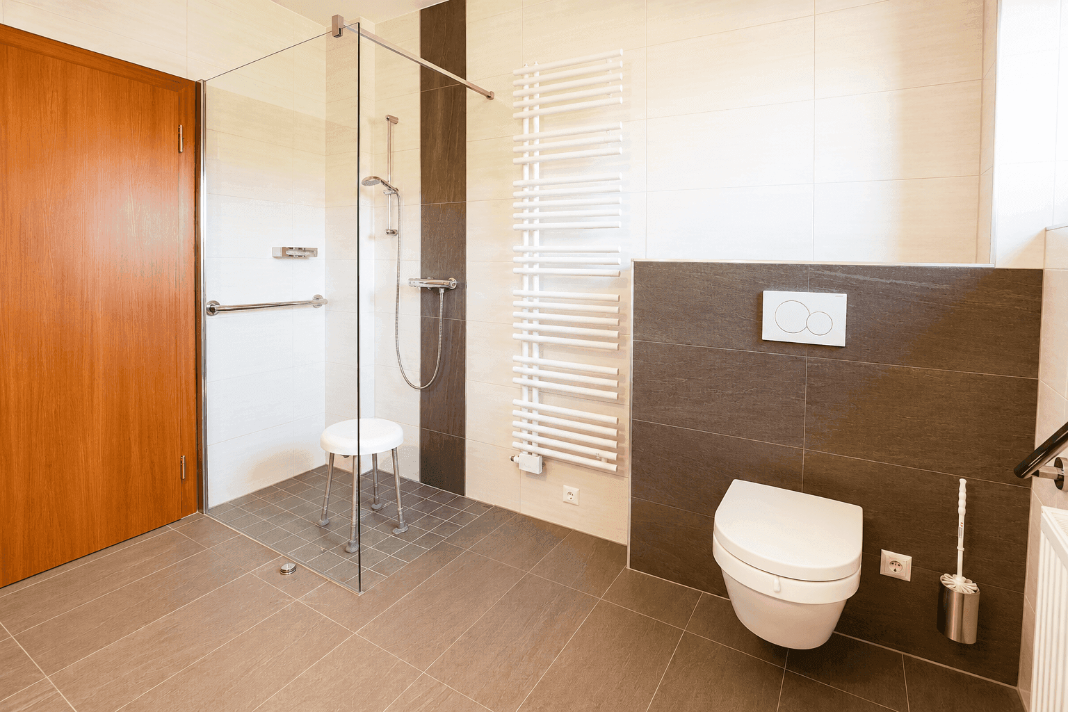 Geräumiges Badezimmer mit ebenerdiger Dusche, Wand-WC und modernem Handtuchheizkörper.