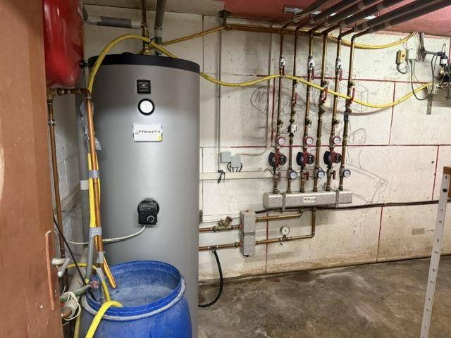 Heizungsraum mit Warmwasserspeicher und Verteilern, gut organisiert und funktional.
