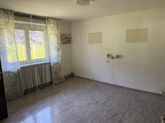 Leeres Wohnzimmer mit großen Fenstern und Fliesenboden, bereit zur individuellen Gestaltung.