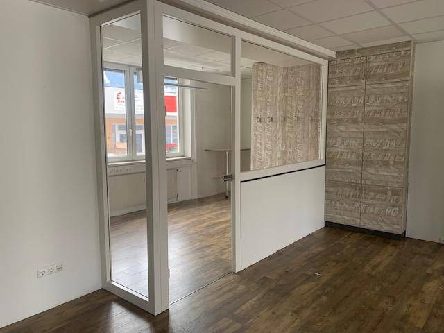 Abgetrennter Bürobereich mit Glaswand und Holzelementen, ideal für Besprechungen oder Einzelbüros mit Tageslicht.
