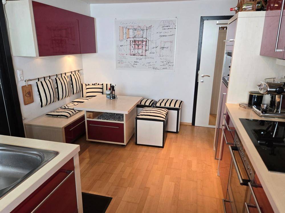 Gemütliche Essecke in der Küche mit Sitzbank, Holzboden und moderner Einrichtung.