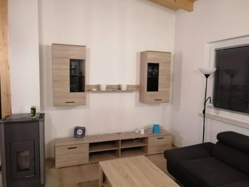Gemütliches Wohnzimmer mit Holzofen, Sofa und modernen Möbeln.