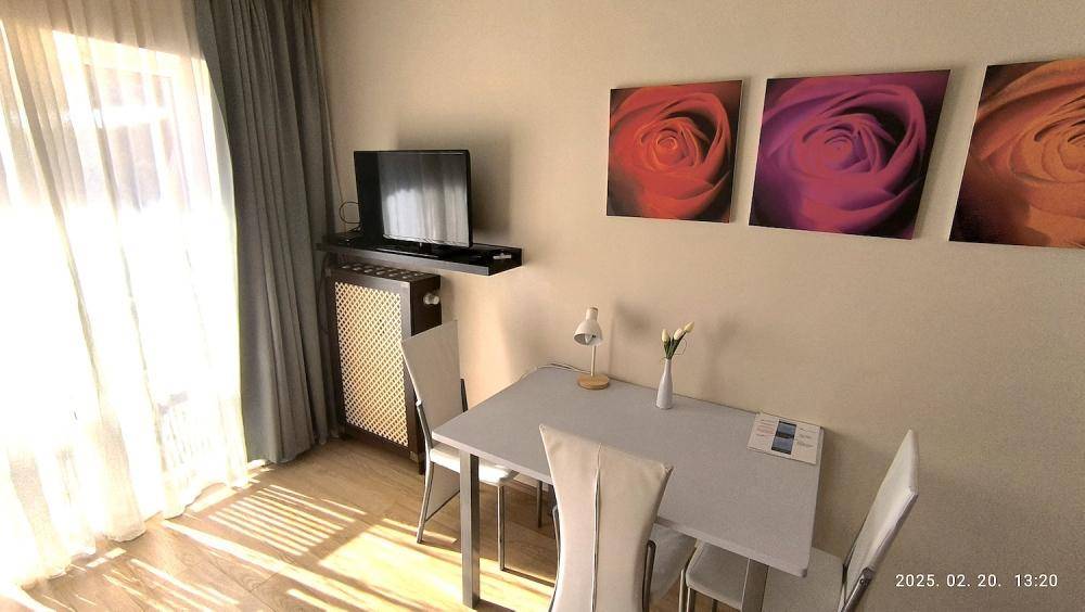 Heller Essbereich mit kleinem Tisch, Stühlen und Fernseher, ideal für Mahlzeiten und Unterhaltung.