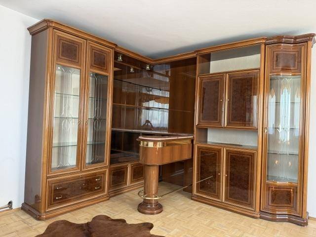 Elegante Wohnwand aus Holz mit Vitrinen und integrierter Bar, in einem traditionellen Stil.