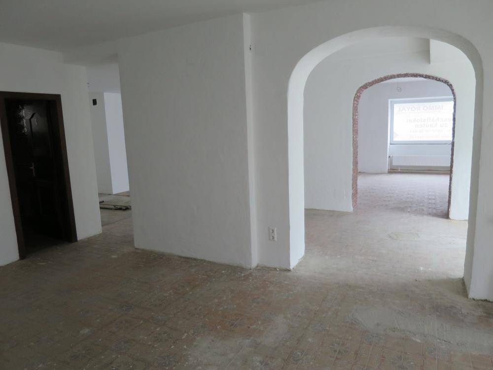 Geräumiger, leerer Innenraum mit mehreren Bögen und Fliesenboden, bereit für den individuellen Ausbau.