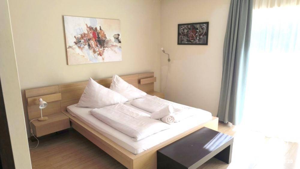 Schlafzimmer mit Doppelbett, Nachttischen und moderner Kunst an der Wand.