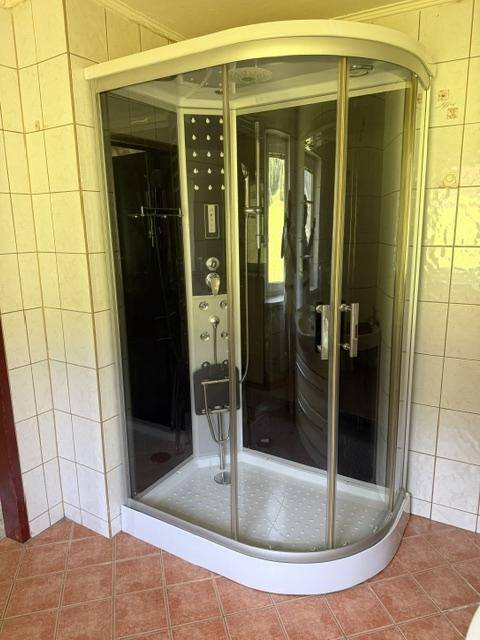 Duschkabine mit Hydromassage-Funktion in einem gefliesten Badezimmer, sauber und gepflegt.