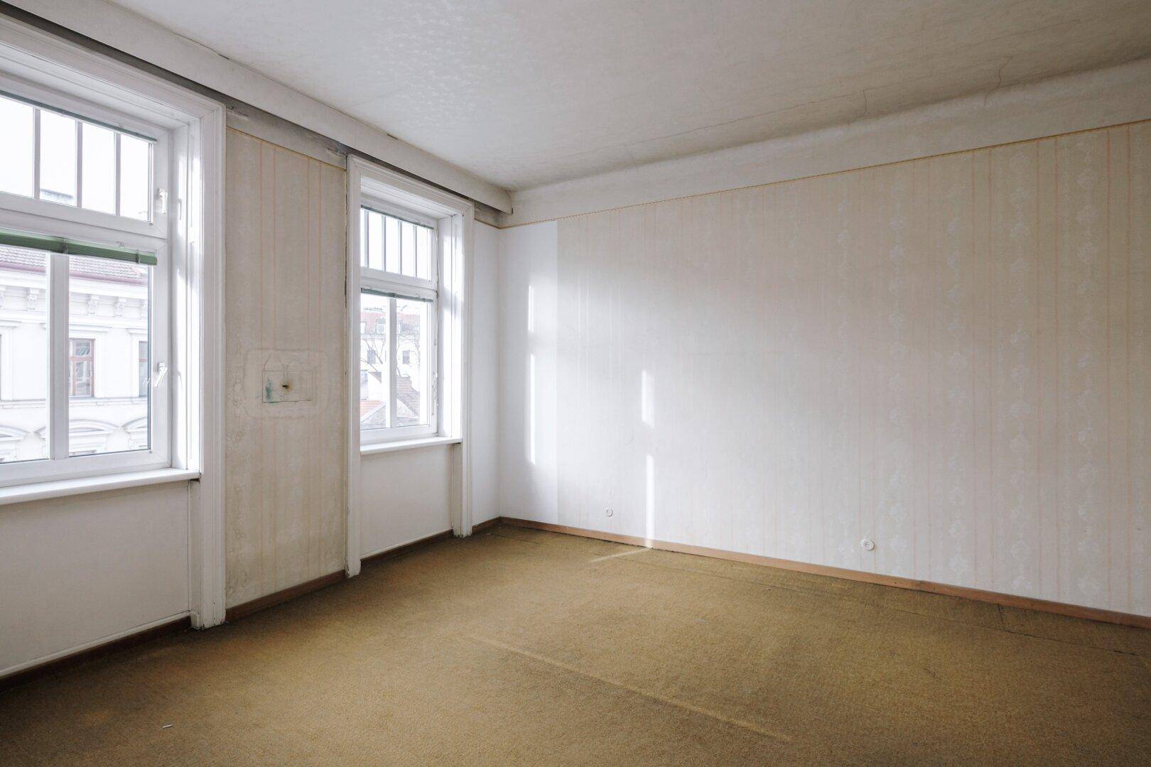 Geräumiges Zimmer mit Teppichboden, hohen Fenstern und viel natürlichem Licht.
