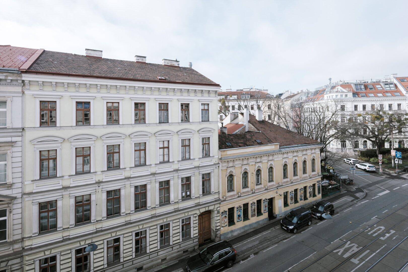Historisches Gebäude mit klassischer Fassade und Blick auf die Stadtstraße.