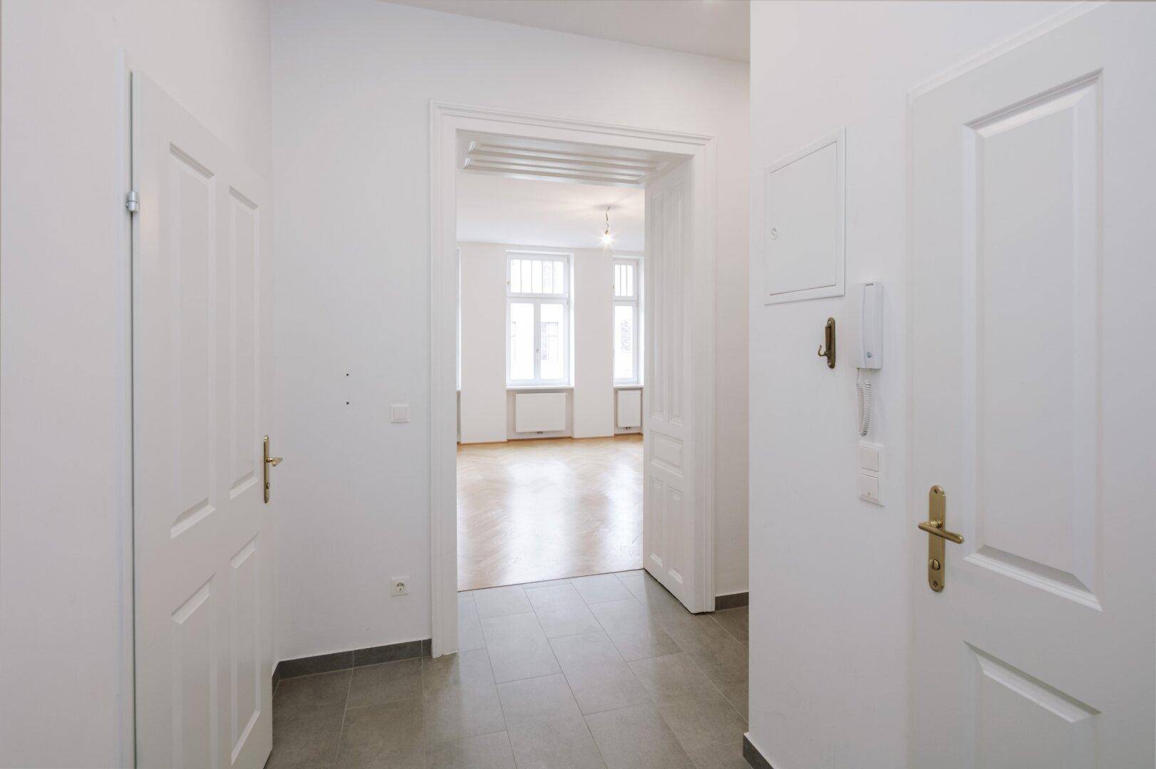 Heller Flur mit Fliesenboden und Zugang zu weiteren Zimmern, typisch für Altbau.