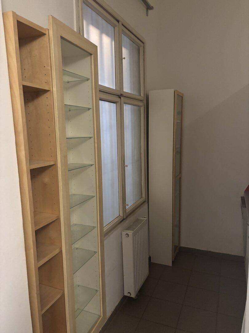 Küchenbereich mit Fenster, Fliesenboden und zusätzlichen Regalen für Stauraum.