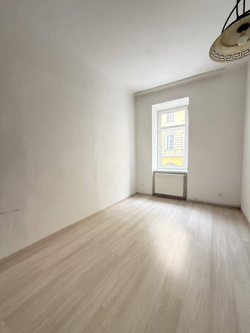 Kleineres, helles Zimmer mit Parkettboden und einem Fenster, geeignet als Schlaf- oder Arbeitszimmer.