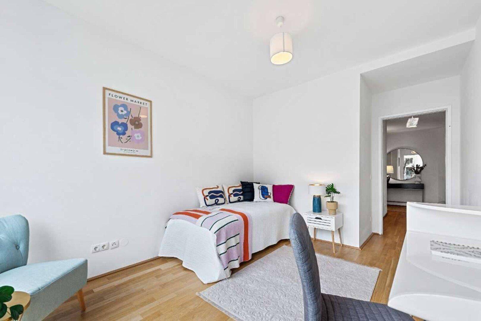 Gemütliches Schlafzimmer mit Holzboden, Einzelbett und farbenfrohen Akzenten in der Dekoration.