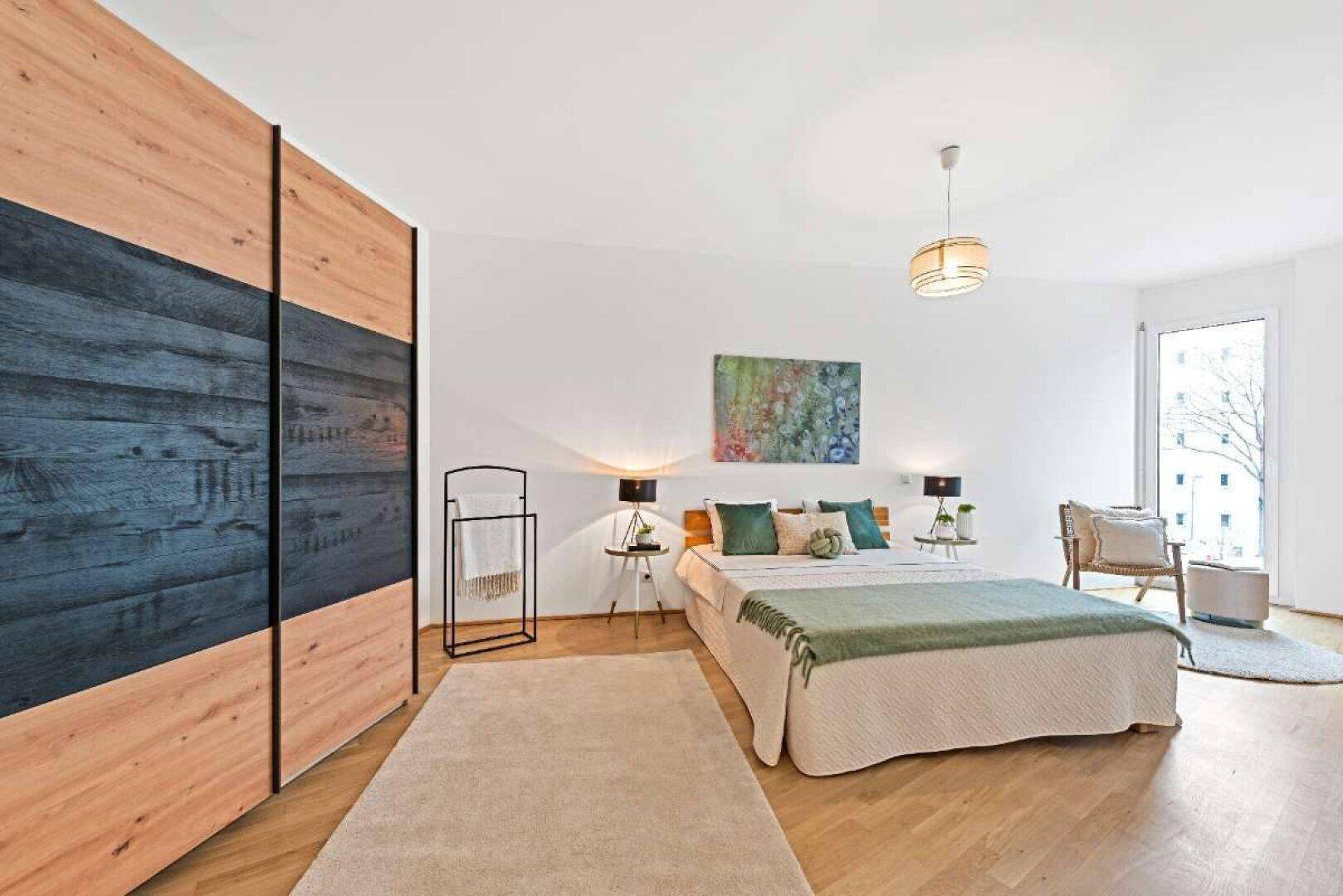 Elegantes Schlafzimmer mit Holzboden, großem Kleiderschrank und viel Tageslicht durch die Fenster.